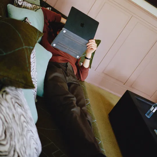 Man resting on sofa with his laptop in The Dean Berlin