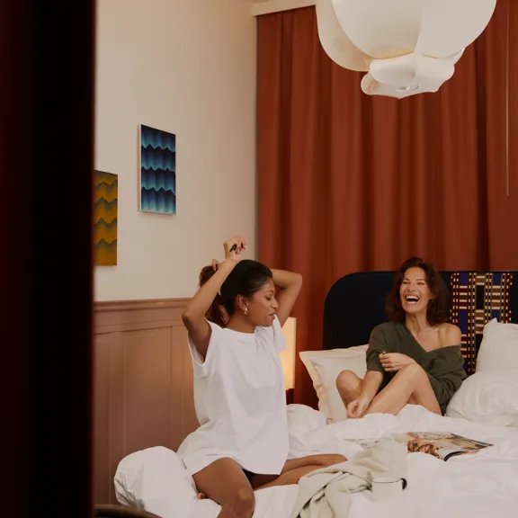 Two women sitting on a bed at The Dean Berlin